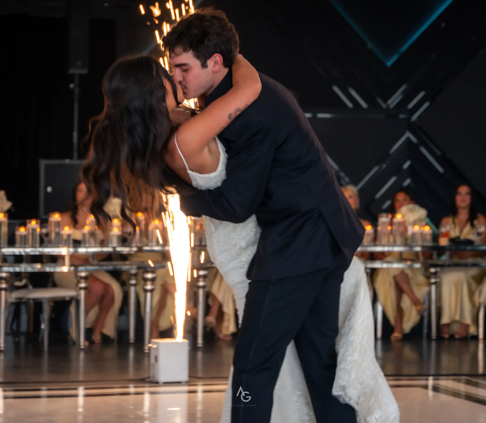Couple sharing first kiss on dance floor with cold sparklers