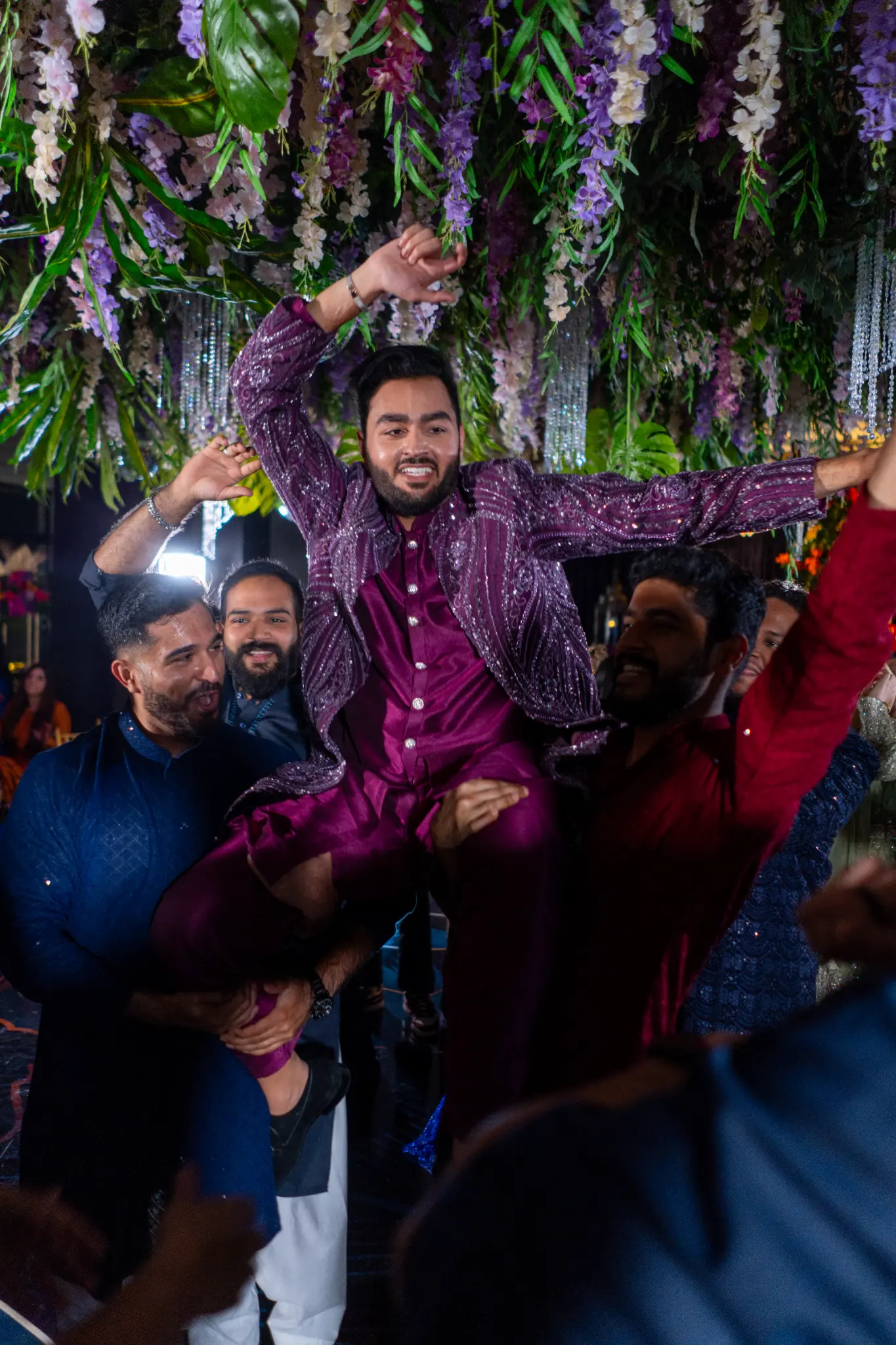 Groom being lifted at South Asian wedding celebration